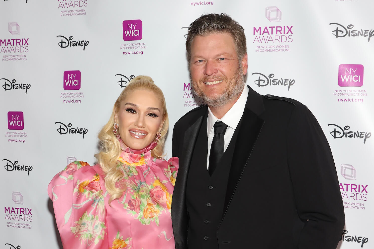 Gwen Stefani and Blake Shelton smiling together at an event