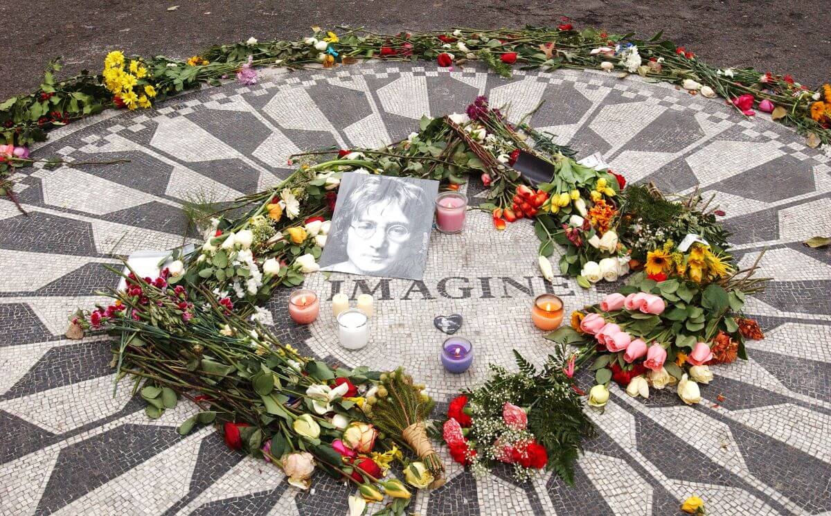 A circular mosaic that says "Imagine" at its center. There are flowers, candles, and a photo of John Lennon on it.