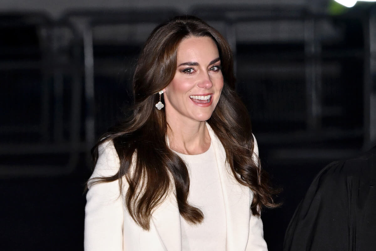 Kate Middleton smiles and looks on wearing white at the 2023 Westminster Abbey Christmas carol concert, 'Together At Christmas'