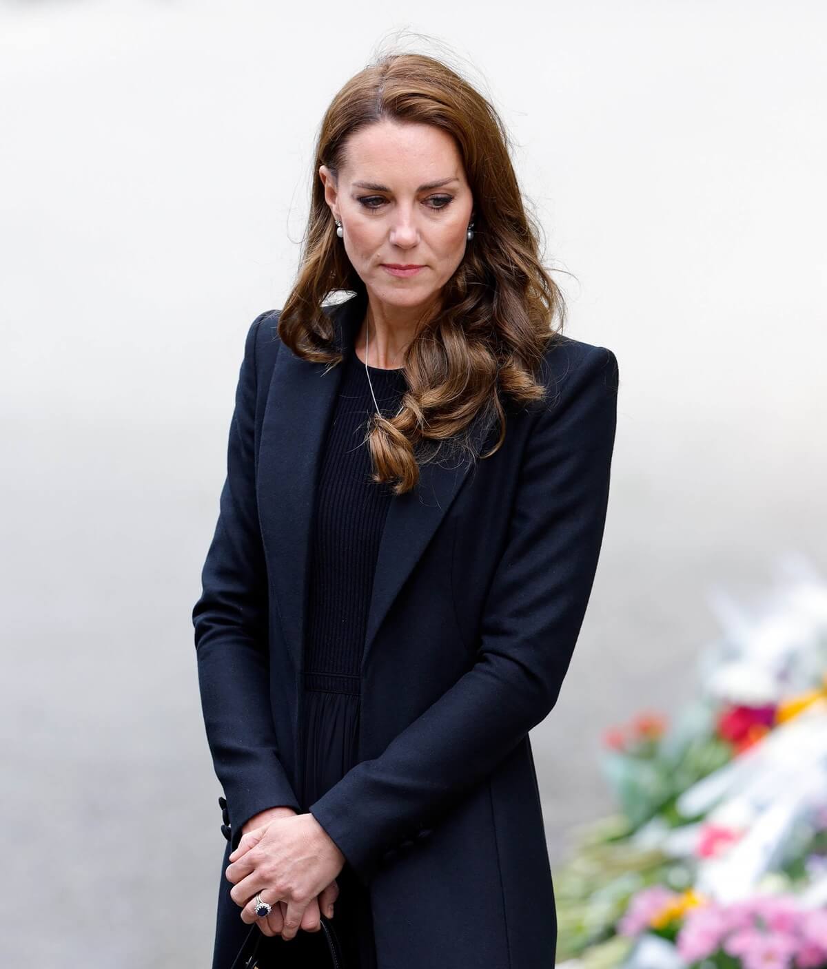Kate Middleton views floral tributes left at the entrance to Sandringham House, the Norfolk estate of the royal family