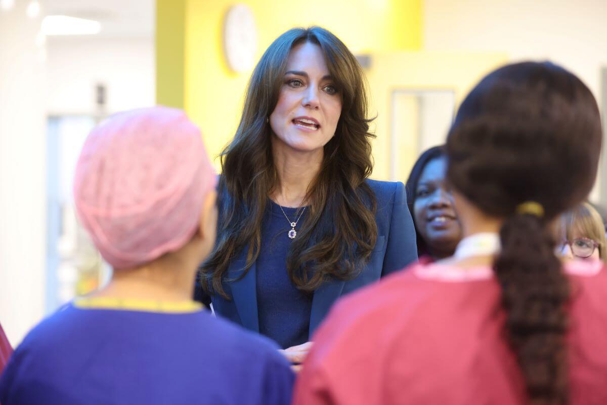 Kate Middleton, who a body language expert says was 'hiding behind her hair,' during the opening of Evelina London's new children's day surgery unit