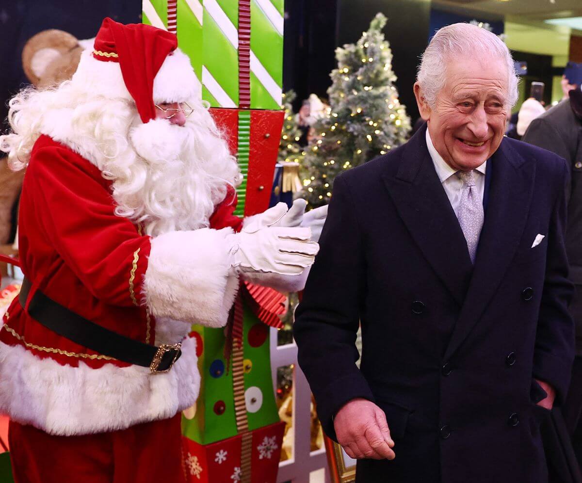 King Charles III reacts as he meets Santa Claus during his visit to the Christmas Market in West London
