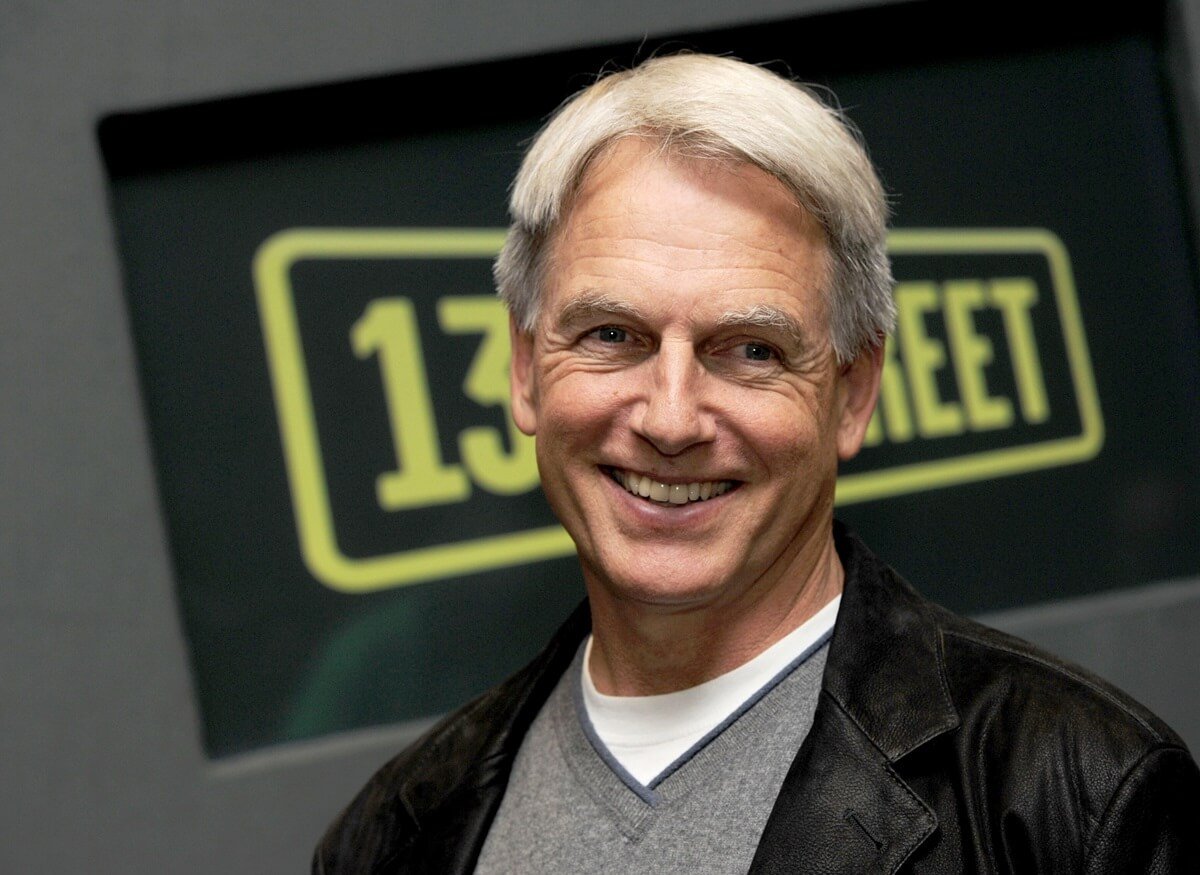 Mark Harmon smiling in a grey shirt and black jacket at the 'NCIS' photocall.