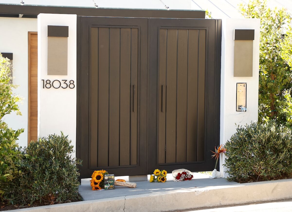 Flowers on the ground outside the gate to actor Matthew Perry's California home