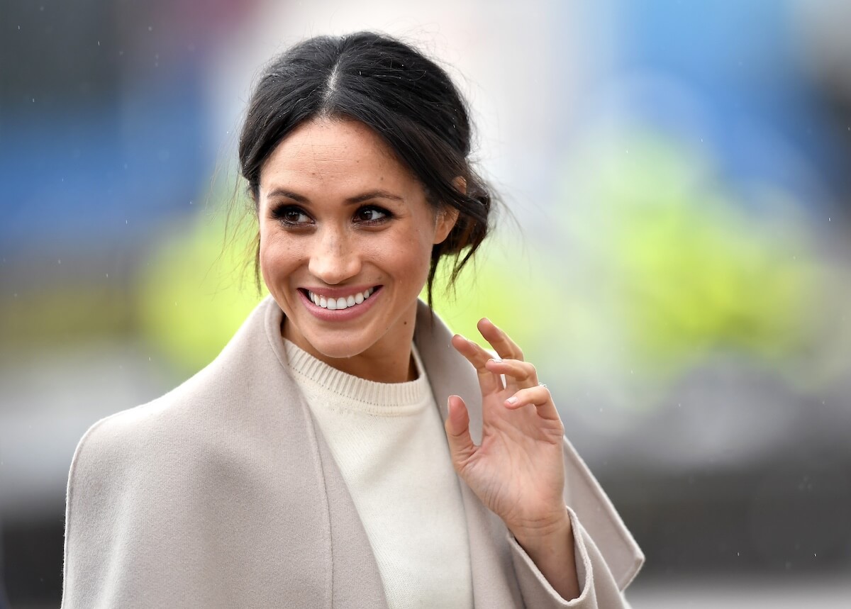 Meghan Markle smiles and waves.