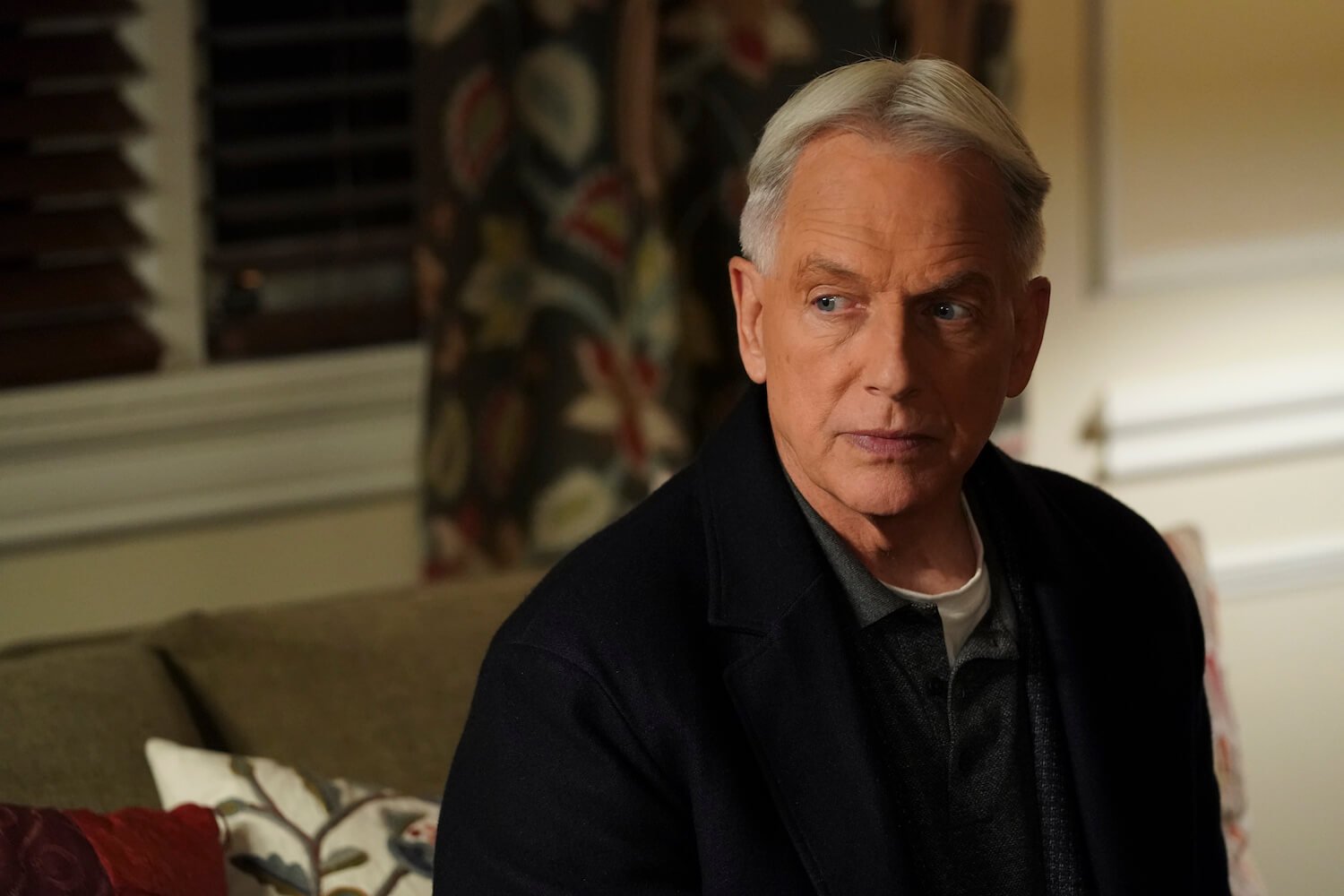'NCIS' star Mark Harmon looking serious while sitting in a room in the show