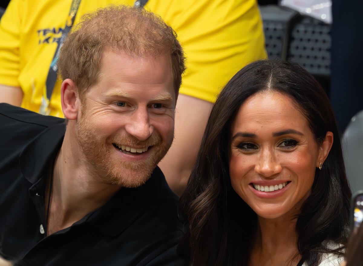 Prince Harry and Meghan Markle, who reportedly 'can't agree' on whether or not to spend Christmas with the royal family, smile