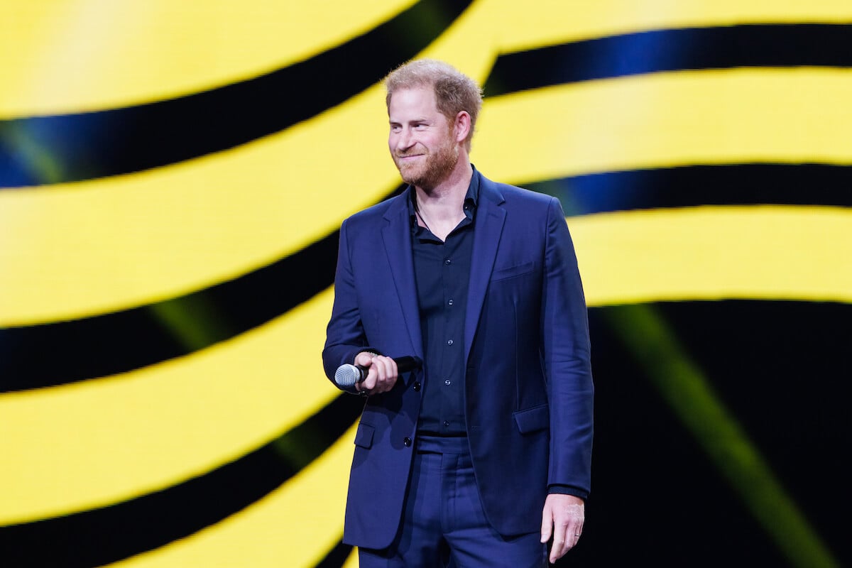 Prince Harry wears a suit and holds a microphone at the 2023 Invictus Games in Germany
