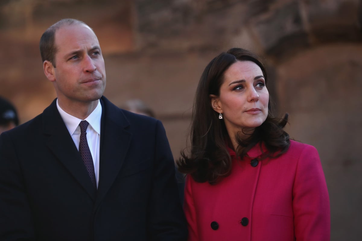 Prince William and Kate Middleton looking to the right as they stand side-by-side.