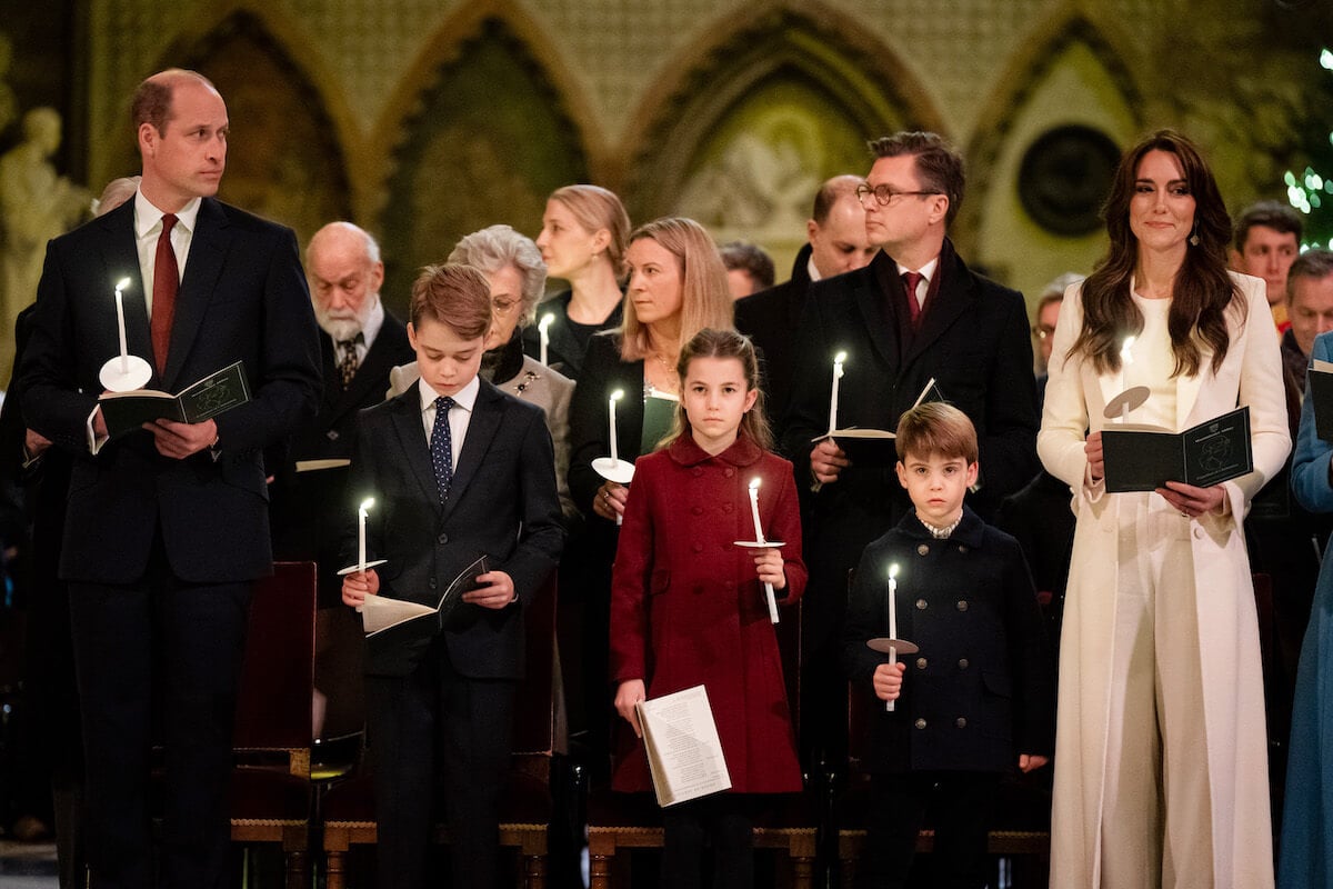 Prince William and Kate Middleton, who an expert believes won't spoil their kids with Christmas presents, stand with Prince George, Princess Charlotte, and Prince Louis hold candles at 'Together At Christmas'