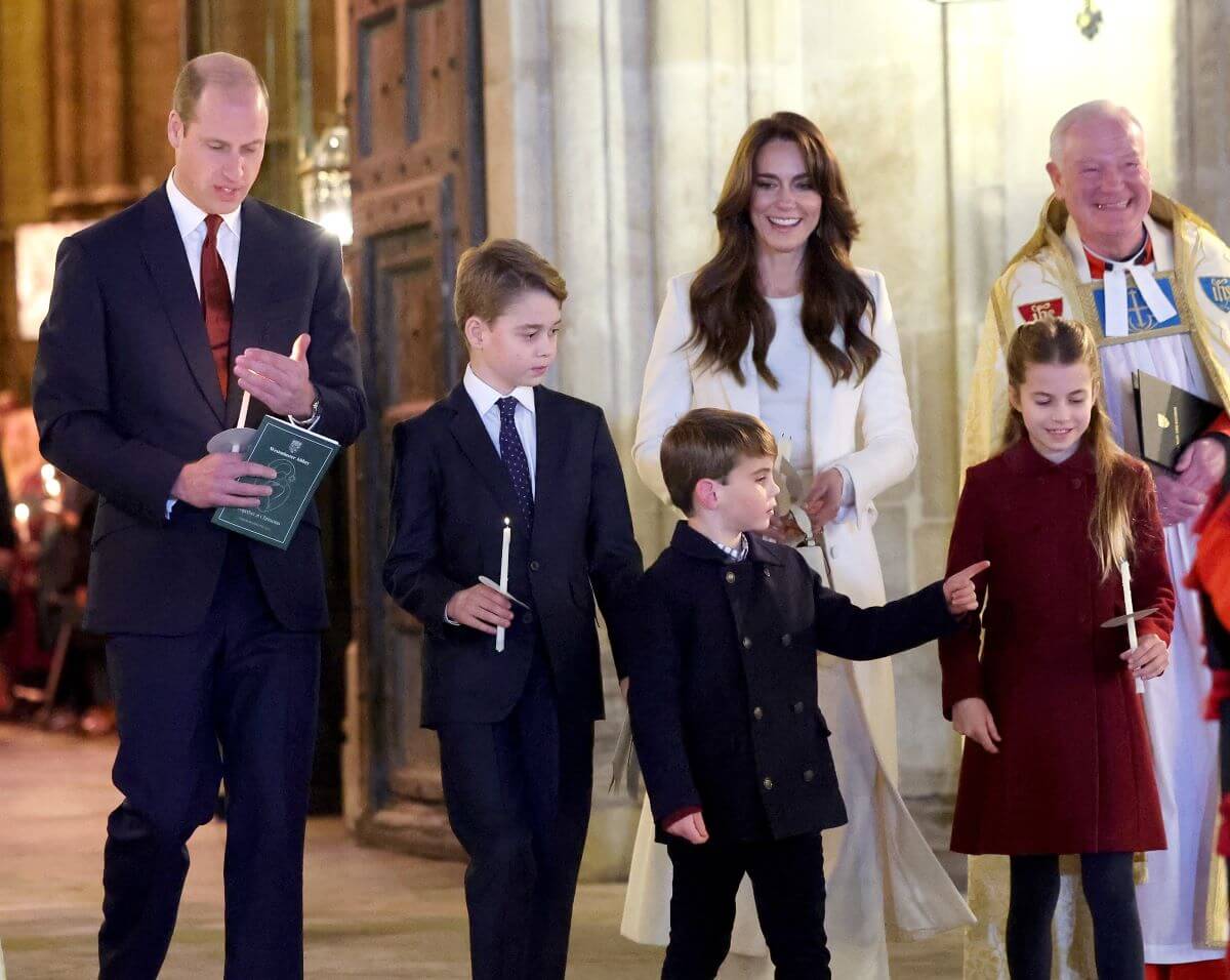 Prince William and Kate Middleton, whose body language in their family Christmas card has been analyzed, process out of The "Together At Christmas" Carol Service at Westminster Abbey with their children