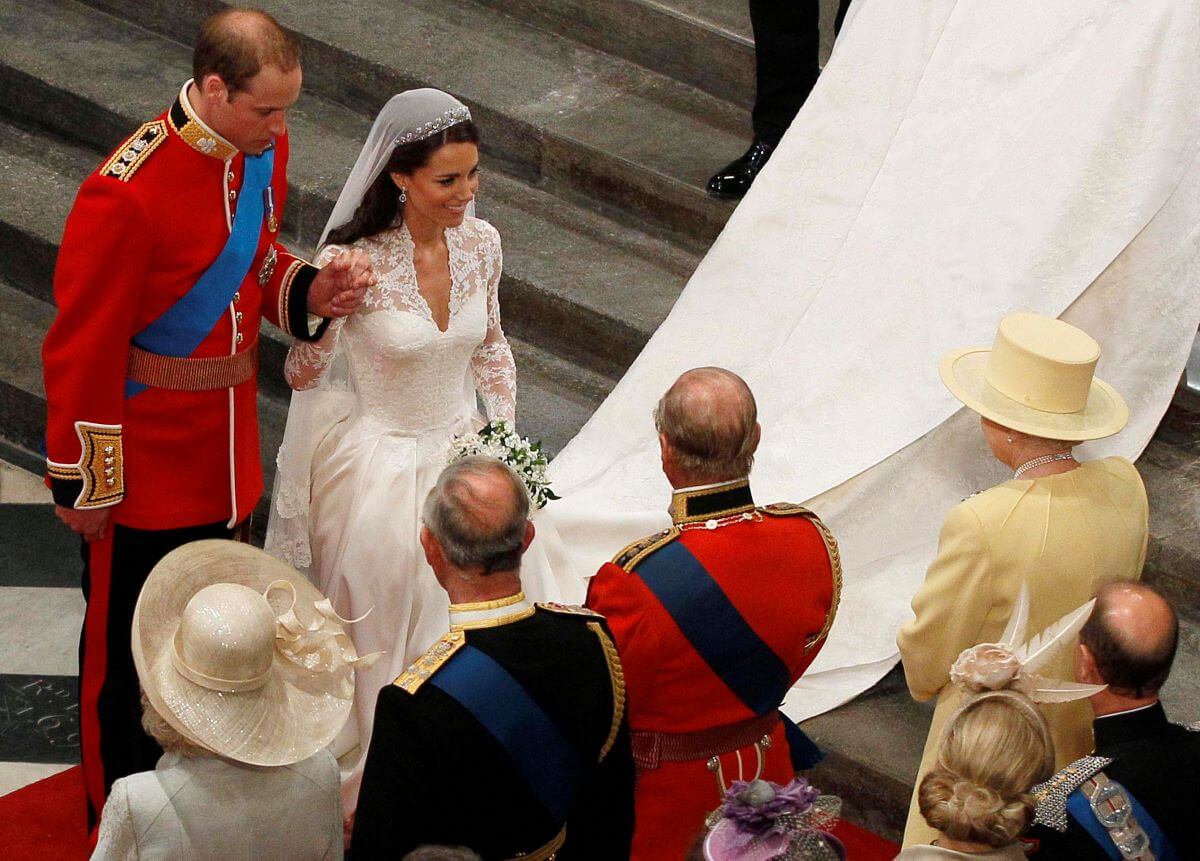 Prince William holds Kate Middleton's hand as they walk down the aisle and greet Queen Elizabeth II