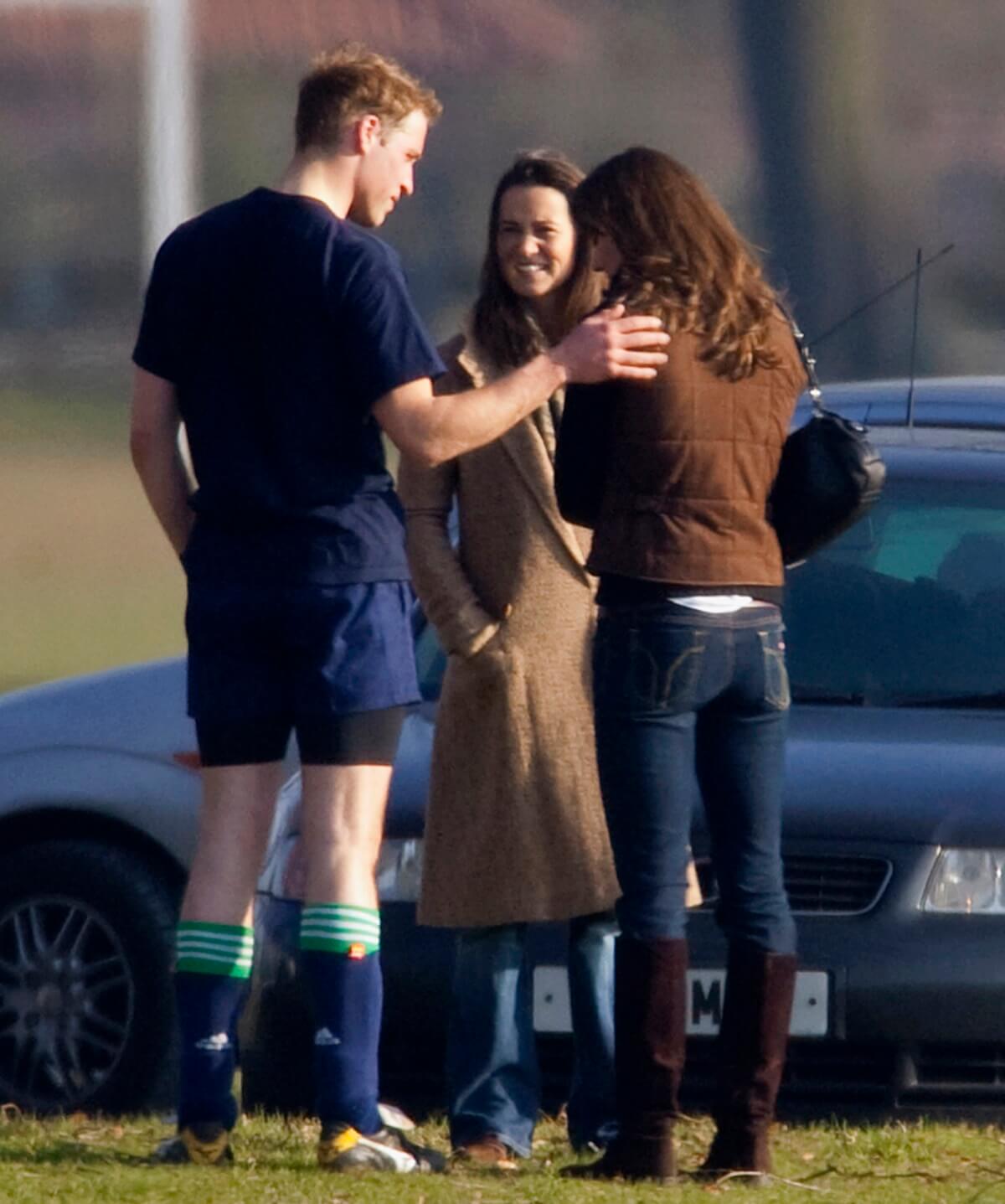 Prince William trying to comfort Kate Middleton, who is turned away from the cameras, during the Field Game in an old boys match at Eton College she attended with her sister Pippa Middleton