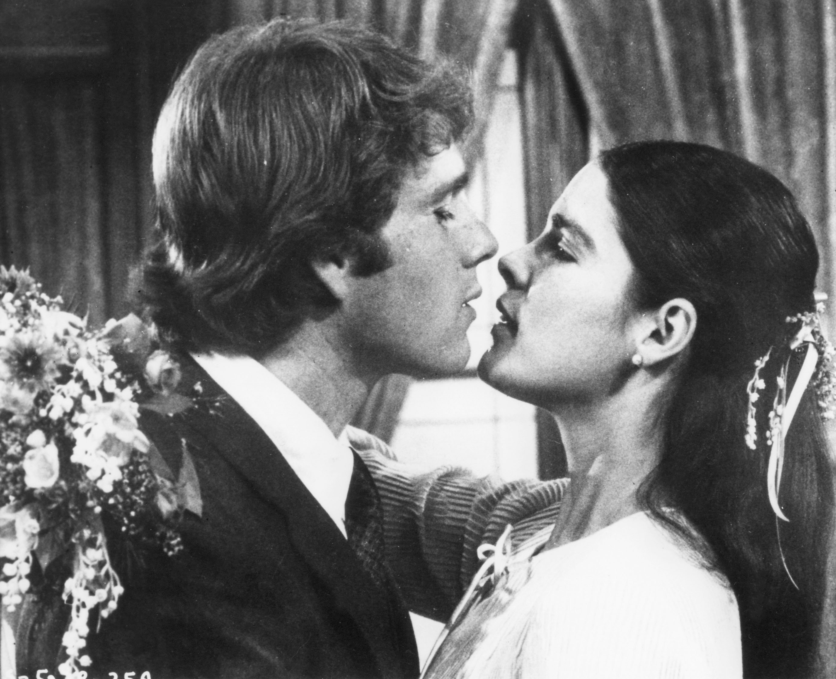 black and white image of Ryan O'Neal and Ali MacGraw kissing in 'Love Story'