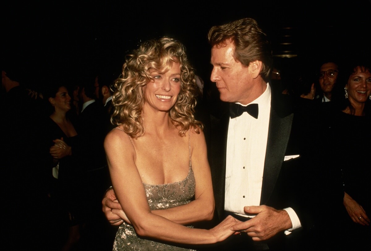 Ryan O'Neal with his arm around Farrah Fawcett