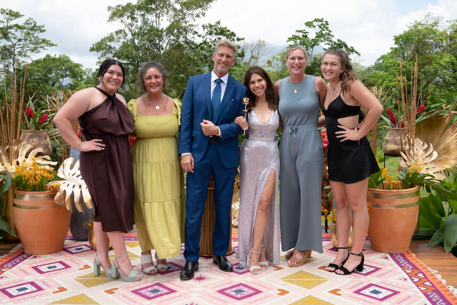 'The Golden Bachelor' stars Gerry Turner and Theresa Nist lined up beside Gerry's daughters and Theresa's family smiling at the camera