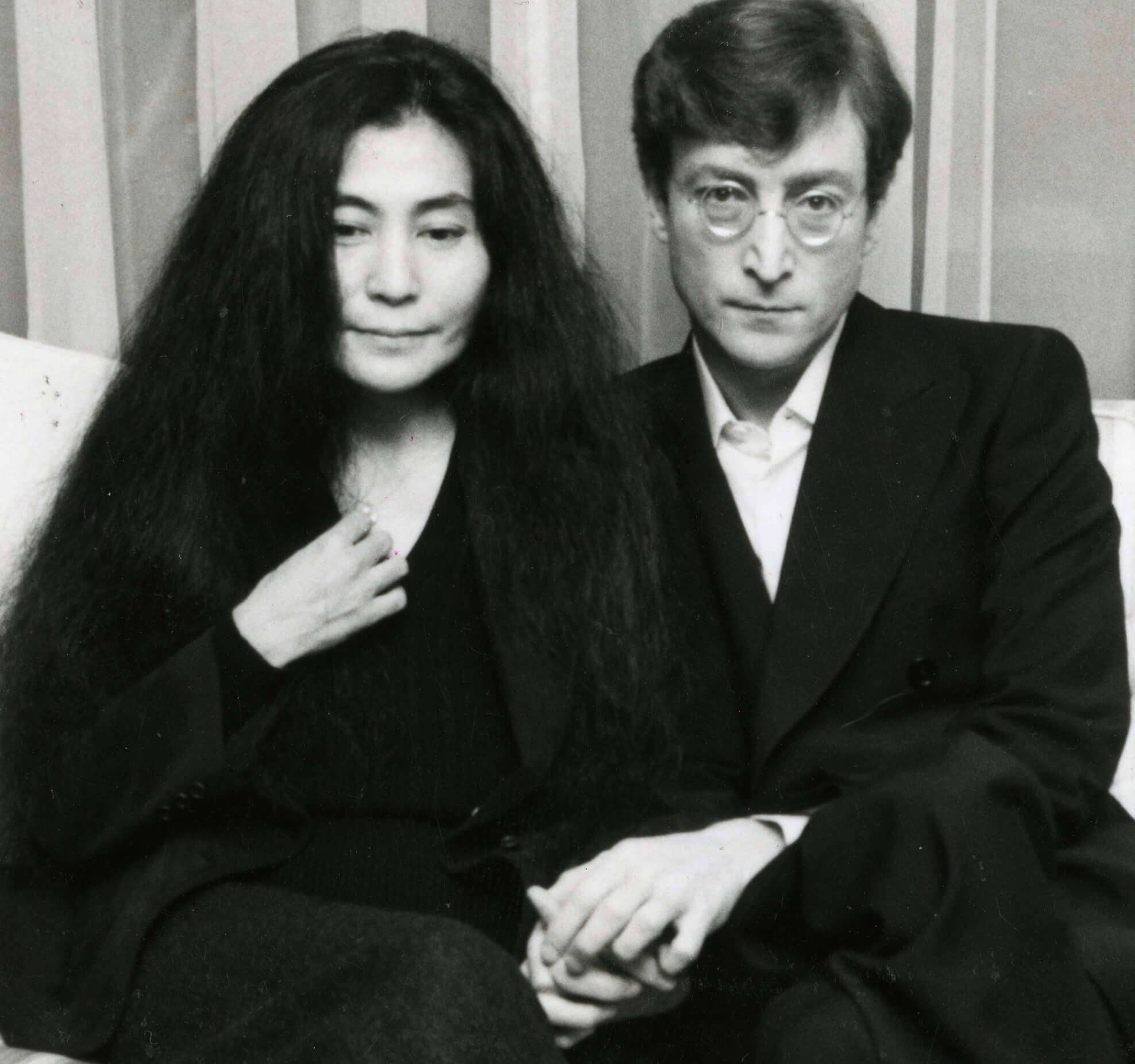 Yoko Ono and John Lennon holding hands