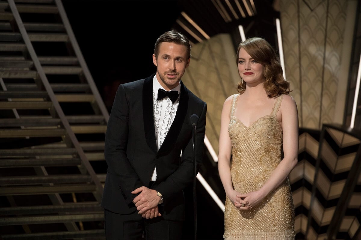 Ryan Gosling and Emma Stone presenting at the Oscars on stage.