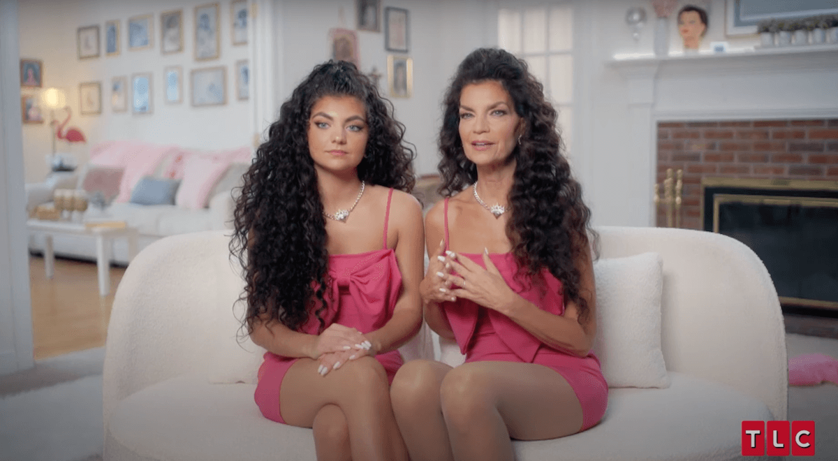 Gabriella and Catherine, both dressed in pink and sitting on a white couch, in 'sMothered' Season 5