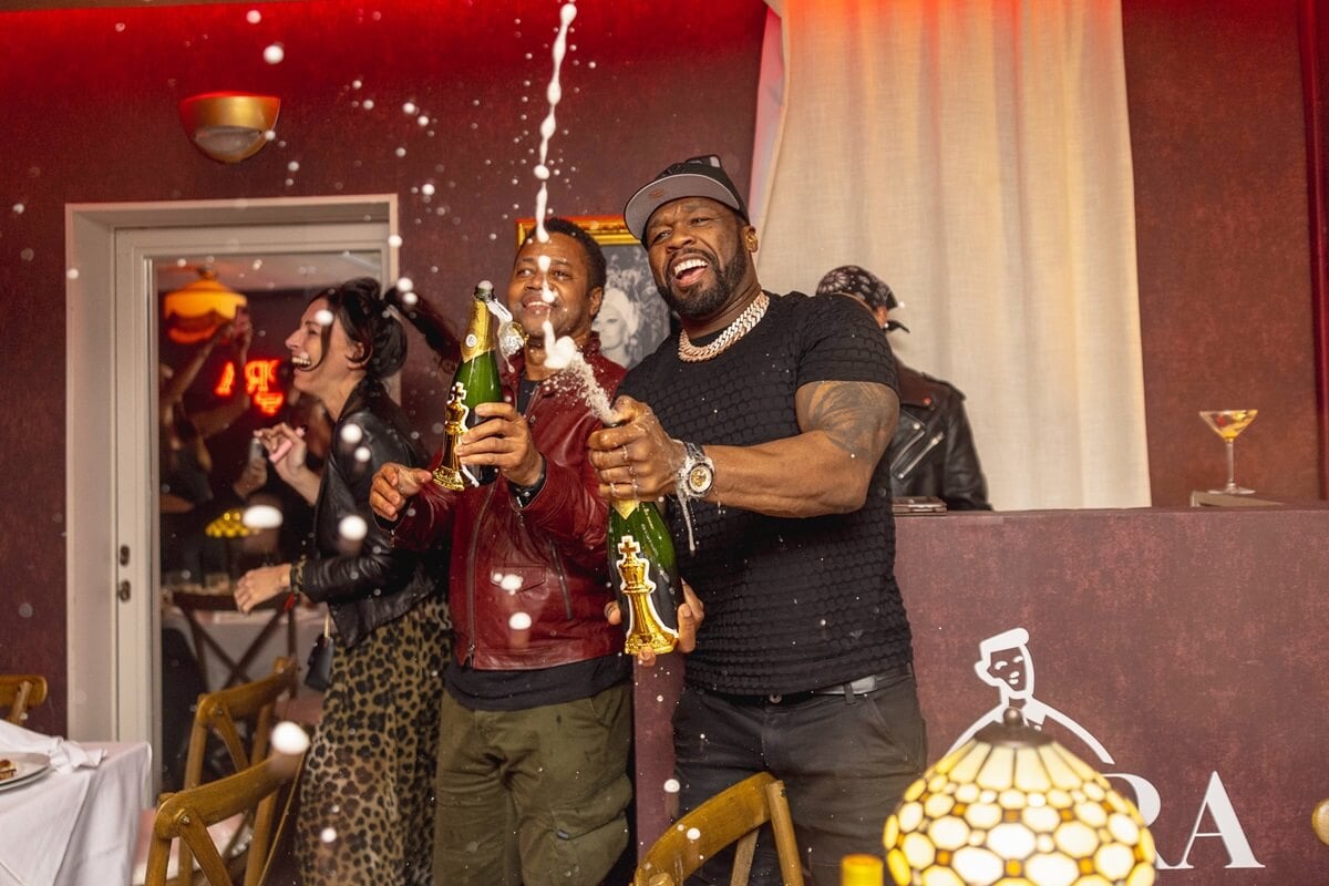 50 Cent popping bottles next to Cuba Gooding Jr. at his birthday.