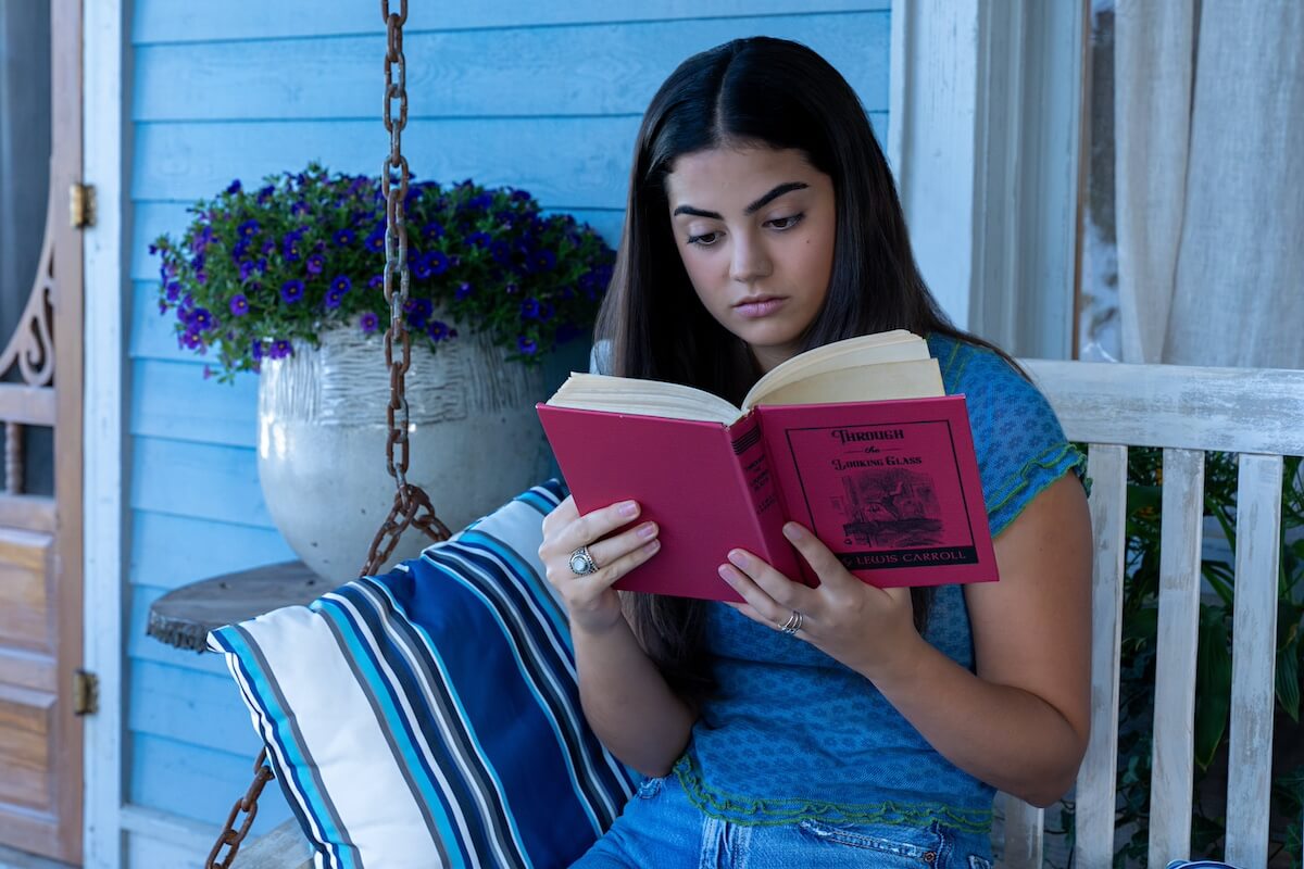 Alice reading a copy of 'Through the Looking Glass' in 'The Way Home' Season 2