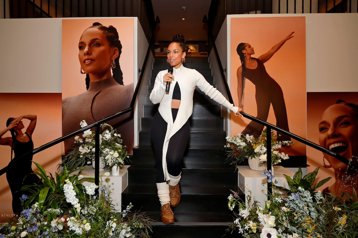 Alicia Keys poses on the stairs at an event for Athleta
