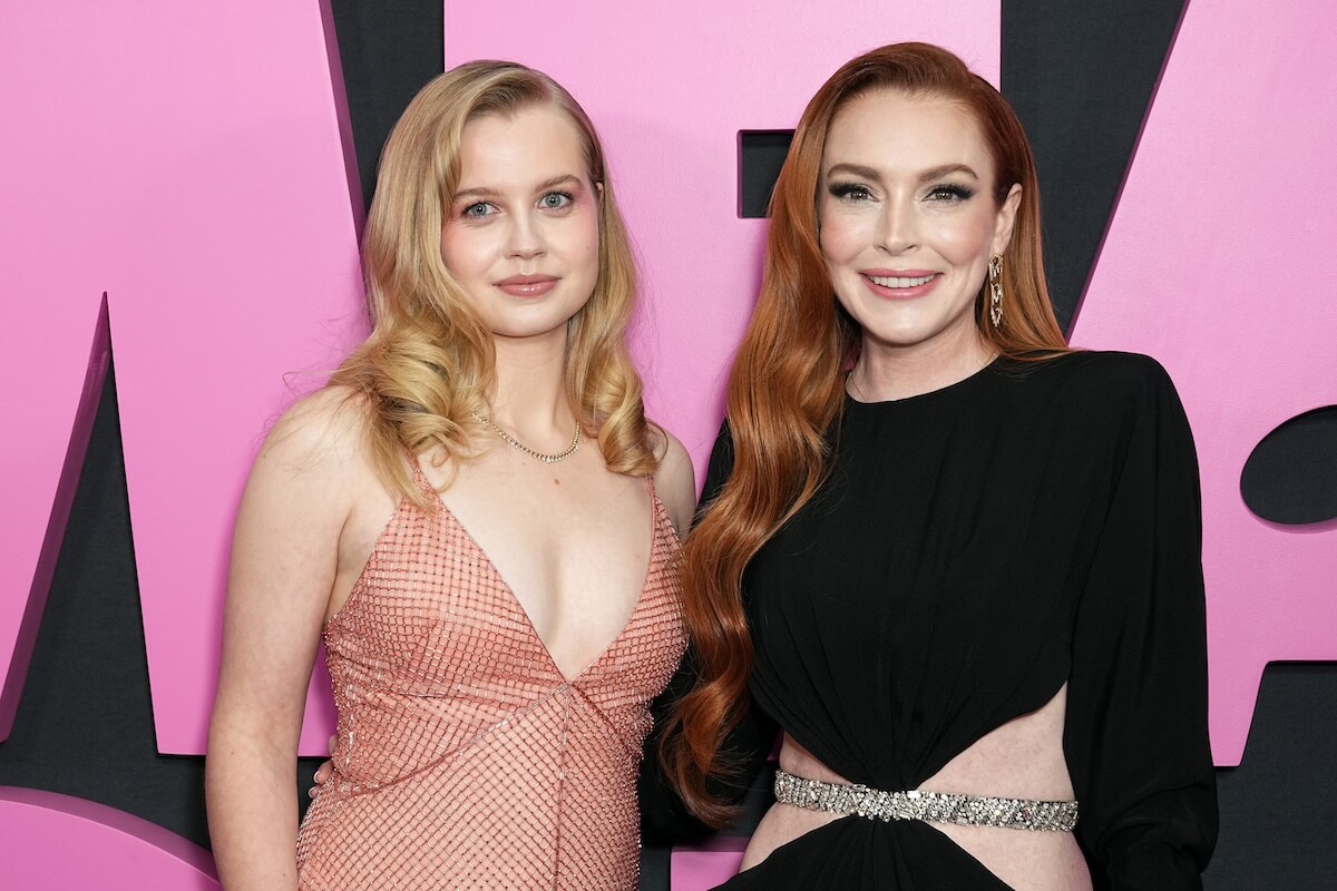 Angourie Rice, in a pink dress, and Lindsay Lohan, in a black dress, pose on the red carpet at the 'Mean Girls' premiere