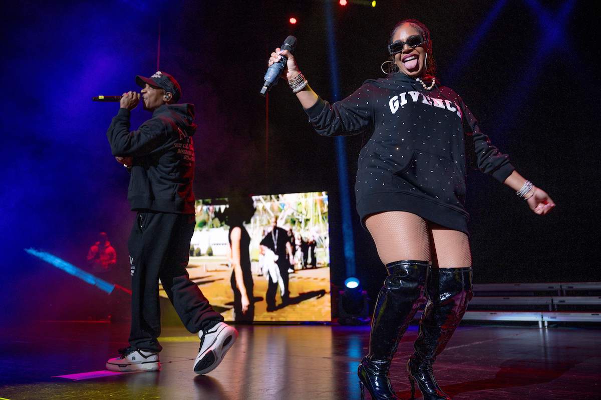 Ja Rule raps into the microphone while Ashanti laughs and sticks out her tongue on stage