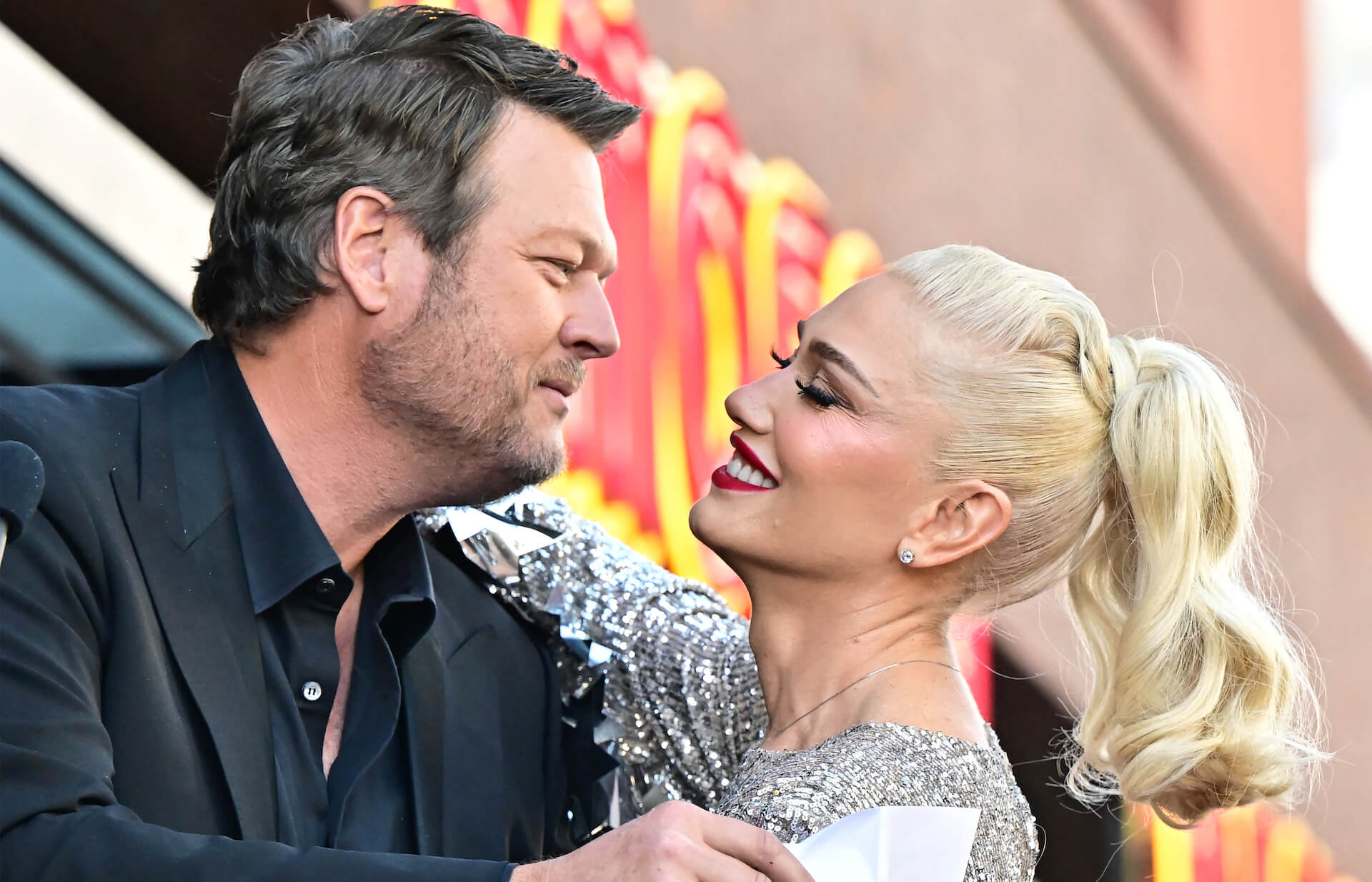 A close-up of Blake Shelton and Gwen Stefani embracing and looking into each other's eyes
