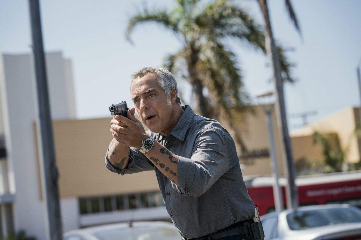 Titus Welliver holds a gun while filming a scene for Bosch