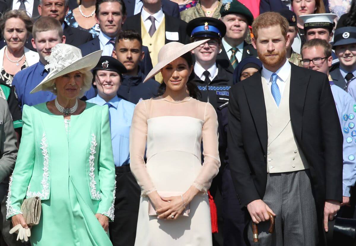Camilla Parker Bowles (now Queen Camilla), Meghan Markle, and Prince Harry pose for a photograph during event at Buckingham Palace
