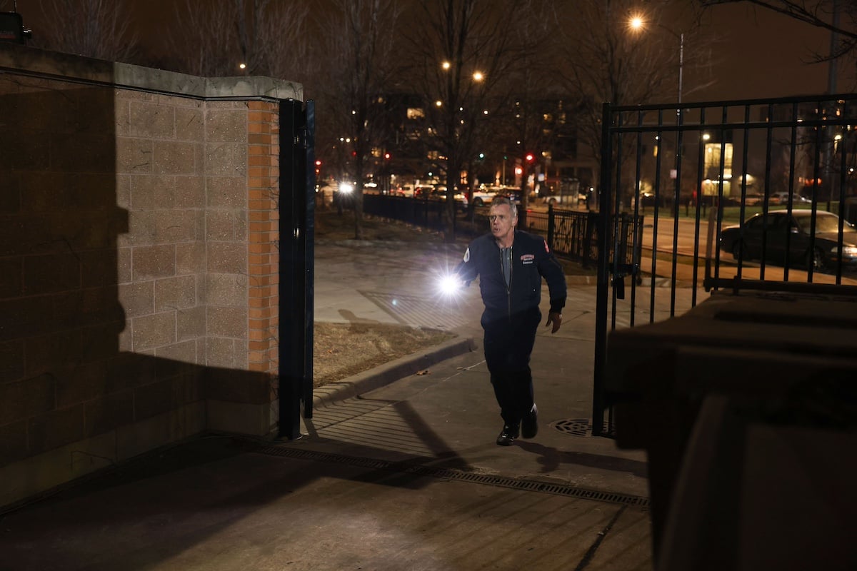 Hermann walking through a gate at night in 'Chicago Fire' Season 12