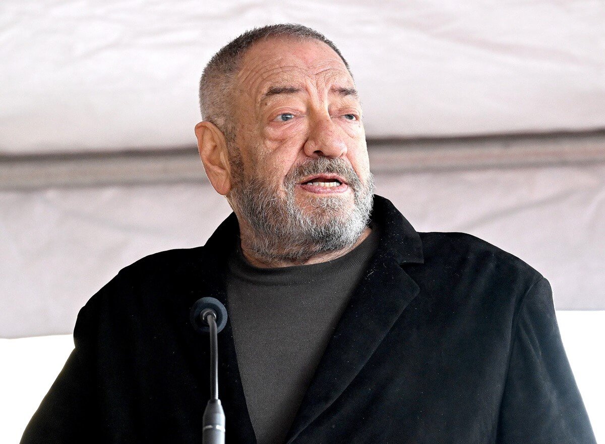 Dick Wolf speaking at at Ice-T's Star On The Hollywood Walk Of Fame Ceremony while wearing a black blazer and grey shirt.