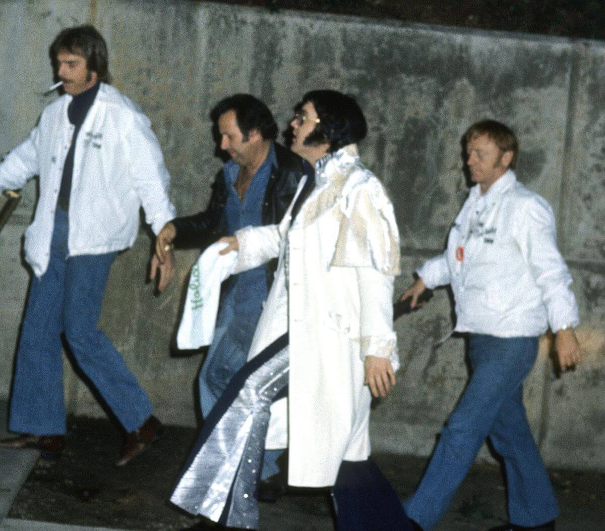 Elvis walks with three of his bodyguards.