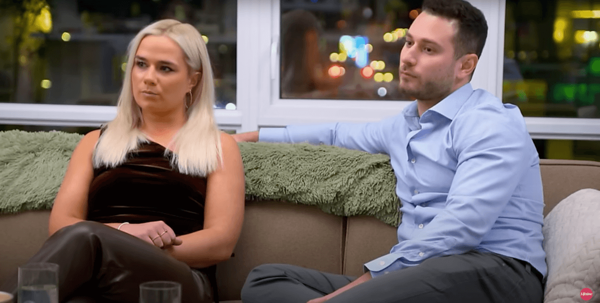 Emily and Brennan sitting on a couch in an episode of 'Married at First Sight' Season 17