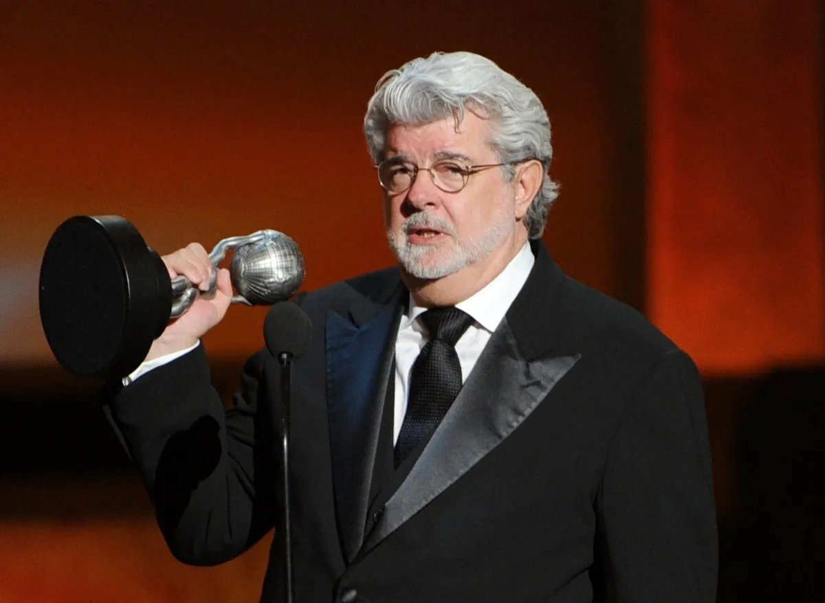 George Lucas on stage holding an award.