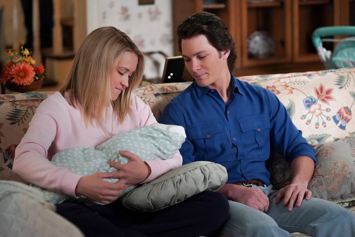Mindy and Georgie sit with their new baby in MeeMaw's house in season 6 of 'Young Sheldon'