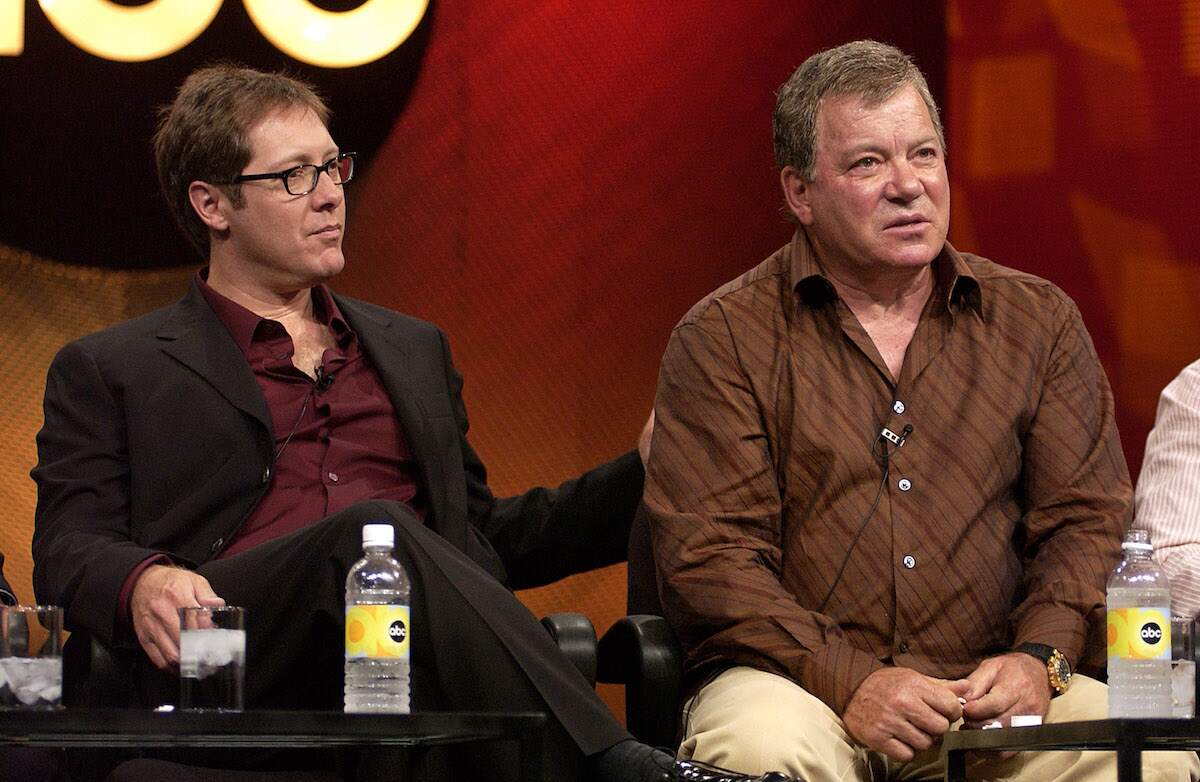 James Spader puts his arm on William Shatner's back as they do a Q&A on-stage in 2004
