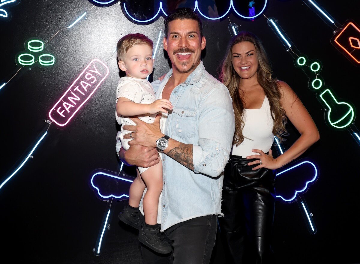 Jax Taylor holding son Cruz and standing next to Brittany Cartwright