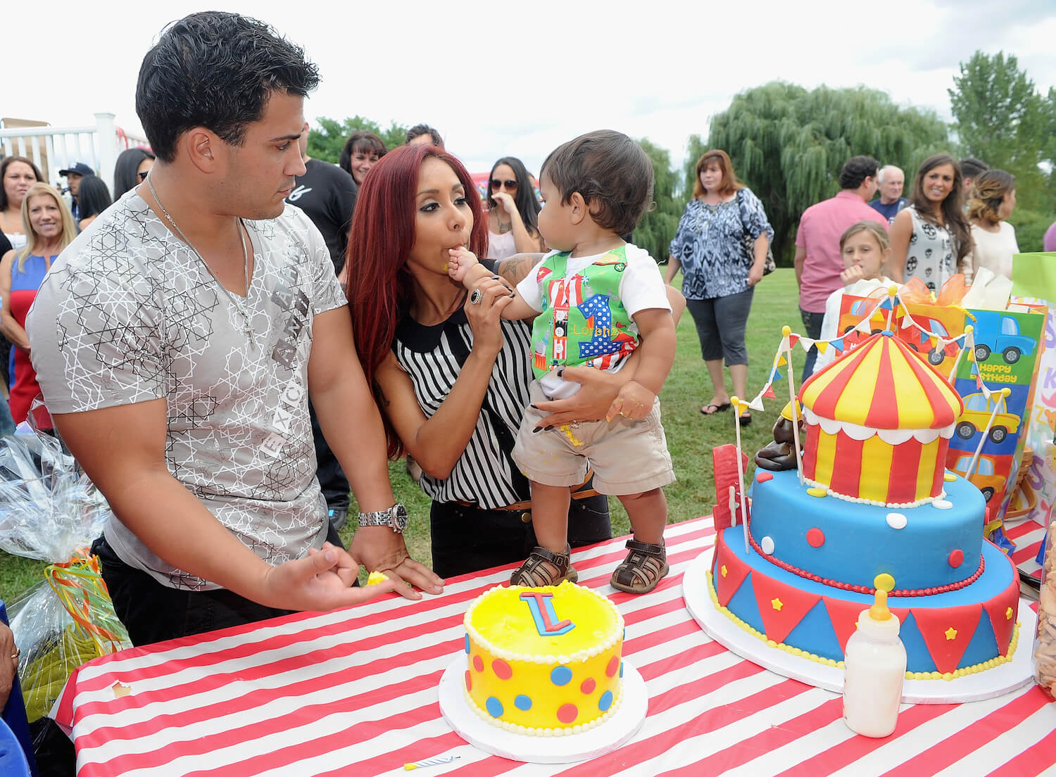 Jionni LaValle and 'Jersey Shore' star Nicole 'Snooki' Polizzi celebrating their son Lorenzo's first birthday. Snooki is holding her son. They're all standing in front of a birthday cake.