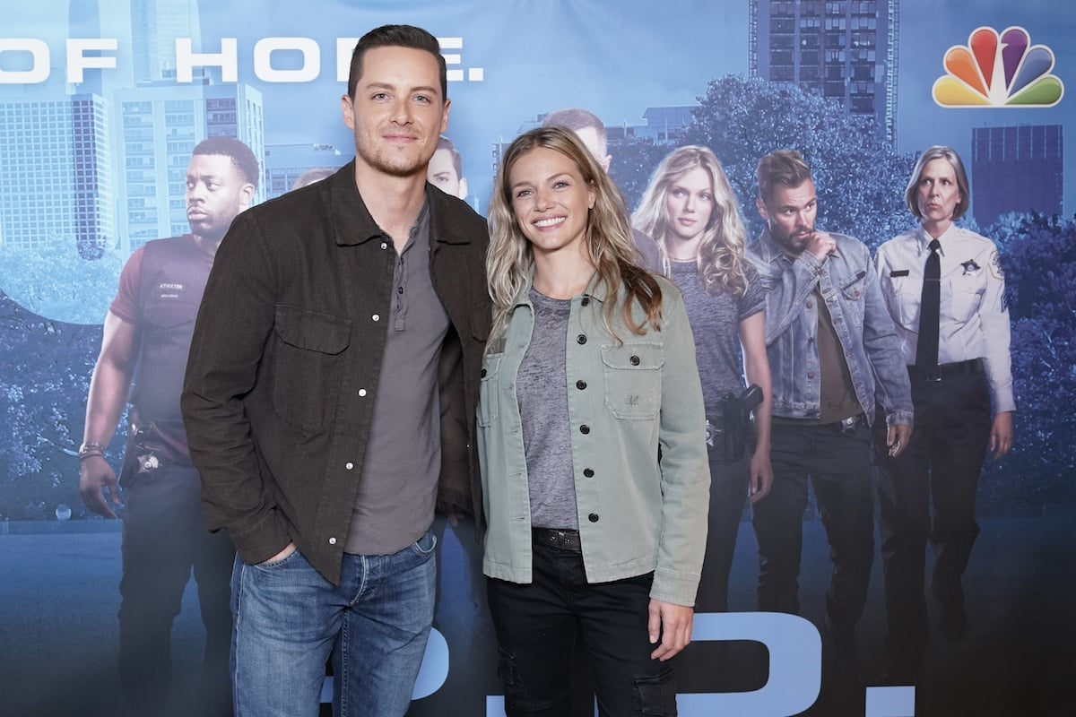 Jesse Lee Soffer and Tracy Spiridakos pose for a photo in front of a One Chicago backdrop