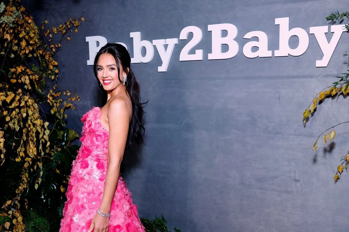 Jessica Alba posing in a pink dress at a Baby2Baby event.