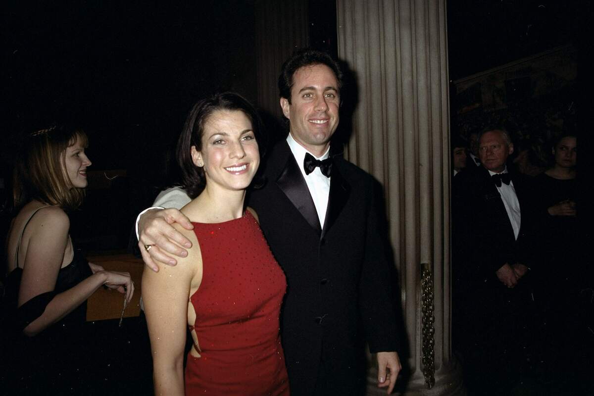 Dating couple Jessica Sklar and Jerry Seinfeld at a gala wearing a red dress and tuxedo