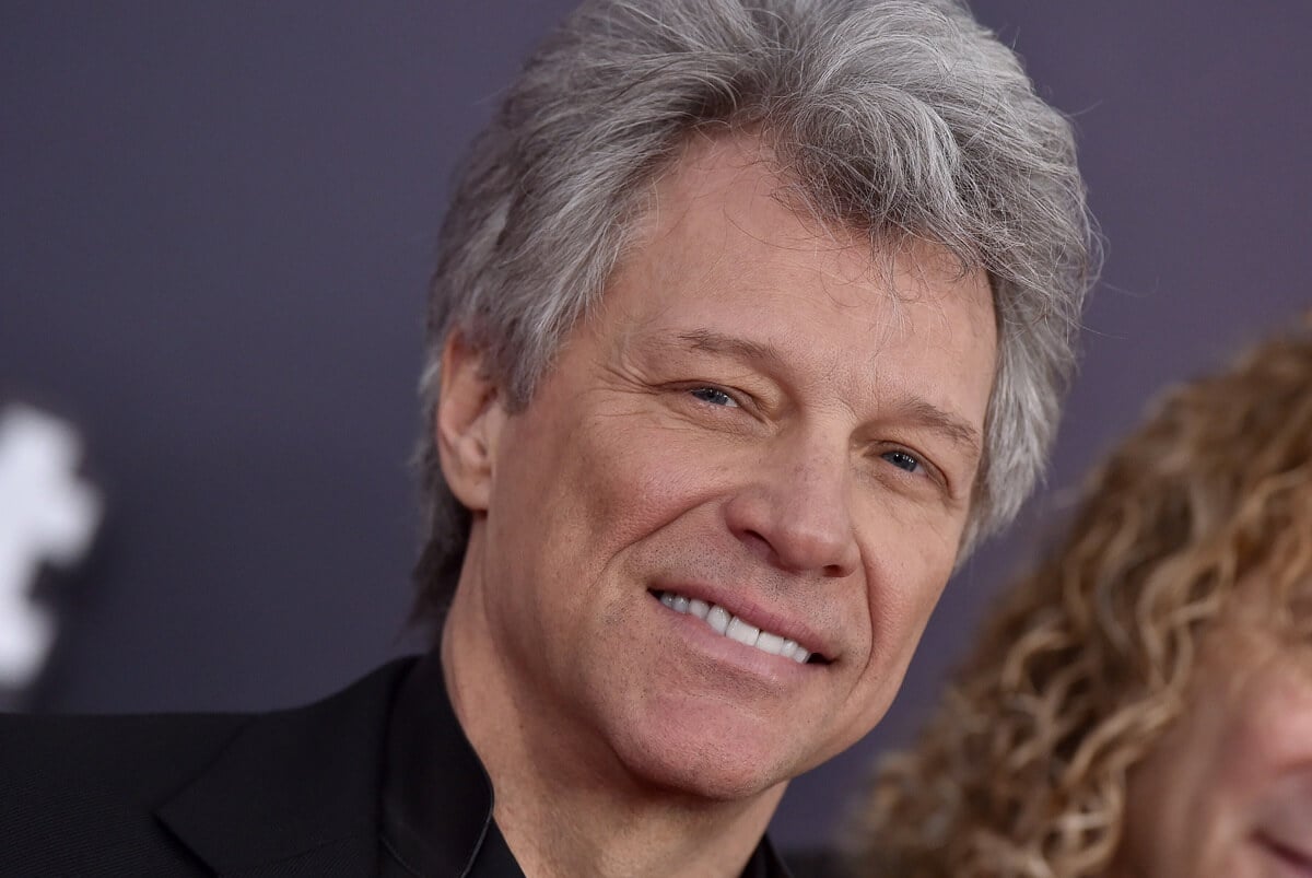 Jon Bon Jovi smiling in a black suit at the 2018 iHeartRadio Music Awards.