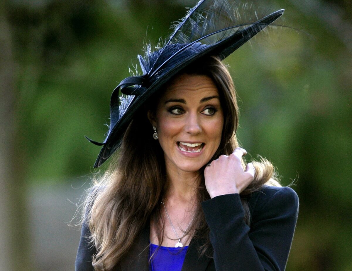 Kate Middleton holding her hair down from blowing as she attends a wedding in Cheltenham, England