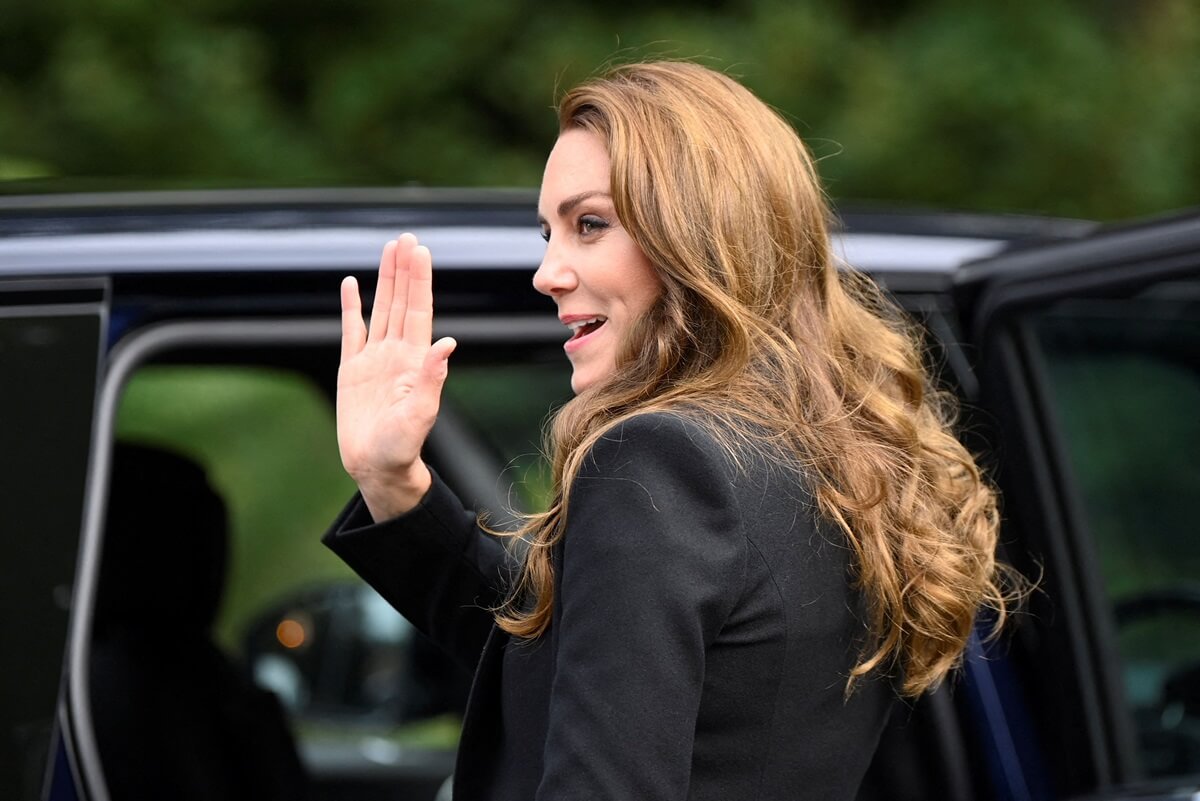 Kate Middleton waves to well-wishers as she leaves after viewing floral tributes left for Queen Elizabeth II at the Sandringham Estate