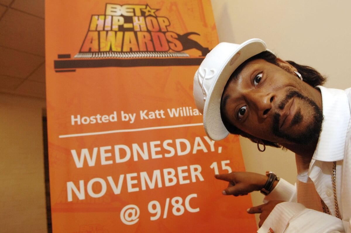 Katt Williams posing at the BET Hip Hop Awards in a white cap and shirt.