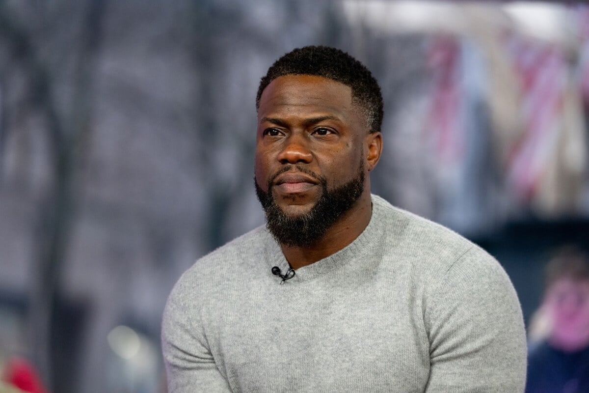 Kevin Hart sitting down while wearing a grey shirt.