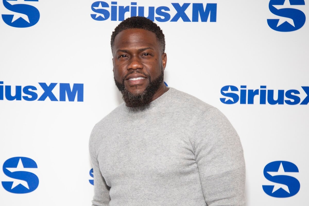 Kevin hart posing in a grey shirt at Sirius XM.