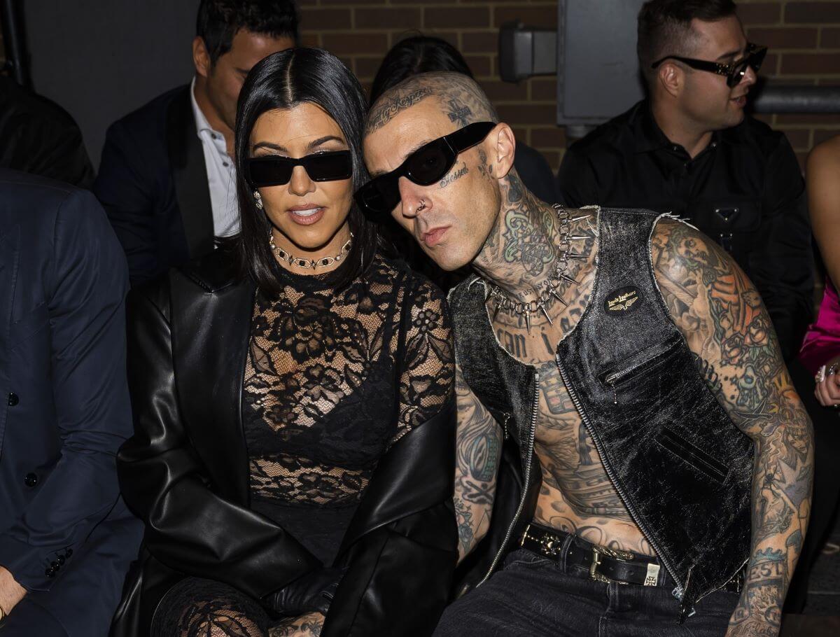 Kourtney Kardashian (L) and Travis Barker attend the Boohoo X Kourtney Kardashian fashion show